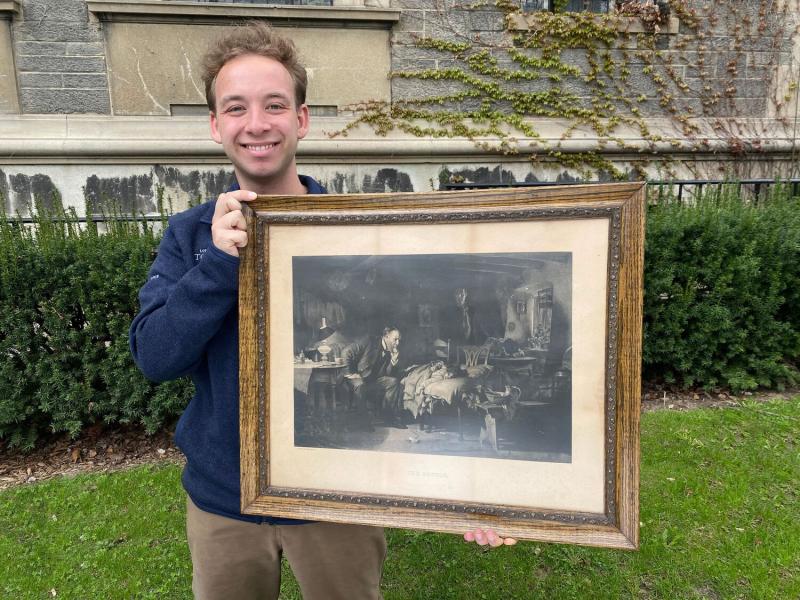 Photo of student holding up painting