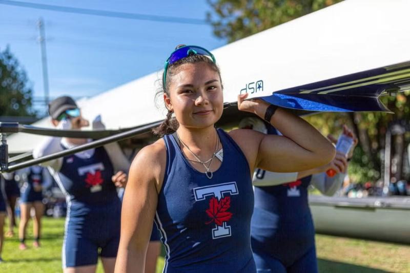 Vanessa Lin carries a rowing boat during her time with the Varsity Blues.